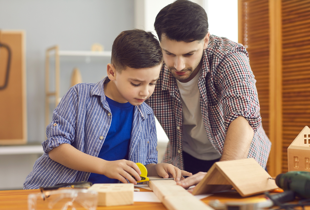 Happy,Concentraited,Father,And,Son,Measuring,Wooden,Details,For,Making
