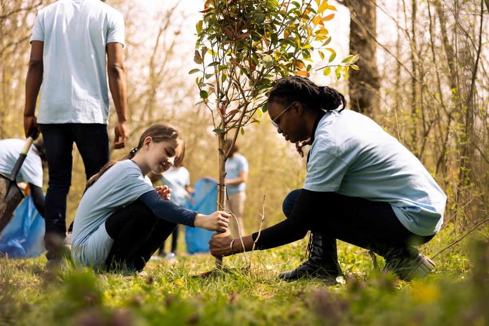 Two,Diverse,Activists,Working,Together,To,Plant,More,Trees,And